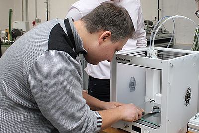 Foto eines Mitarbeiters beim 3-D-Drucker